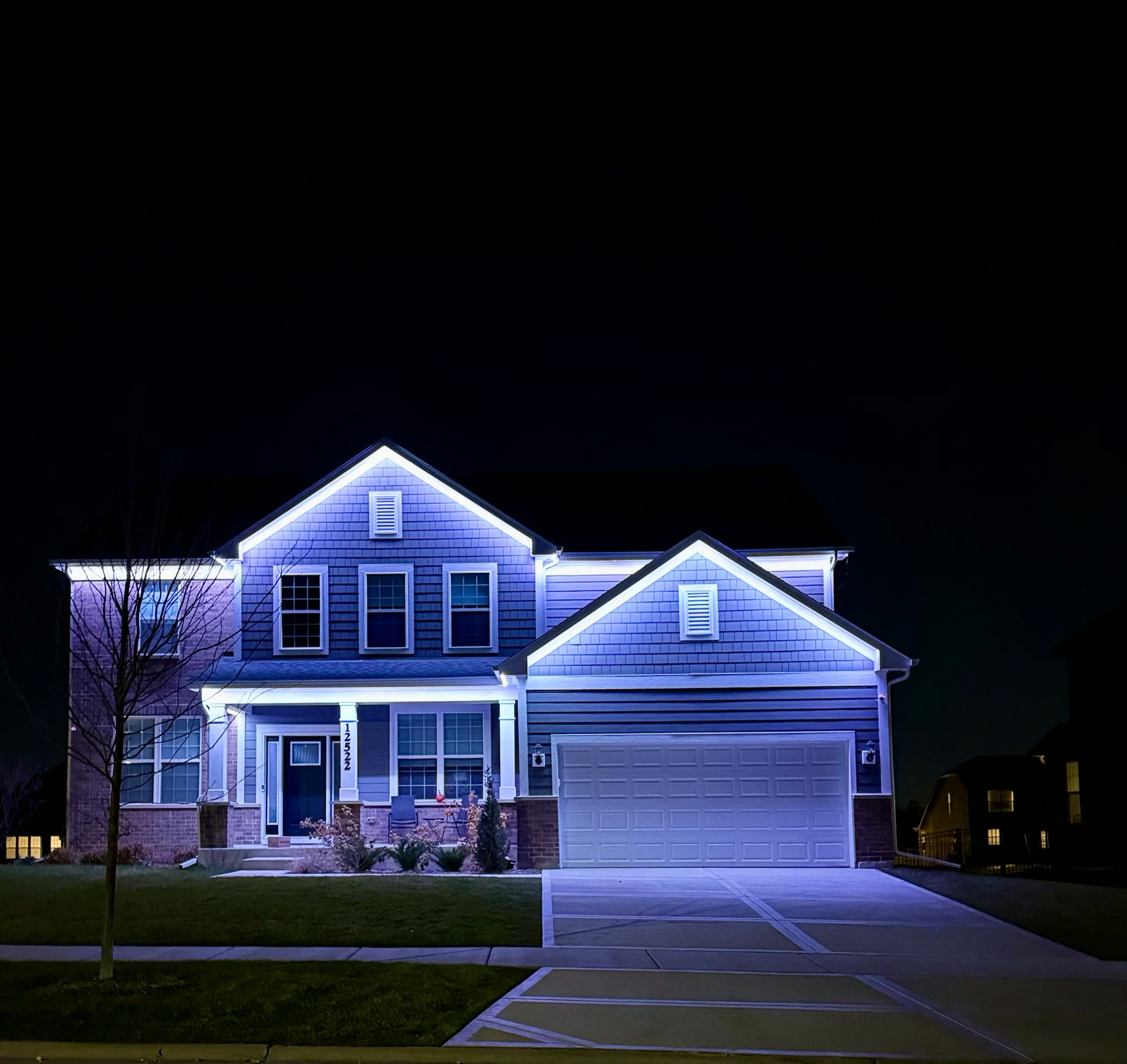 Lusso Lighting installation illuminating a two-story suburban home at night
